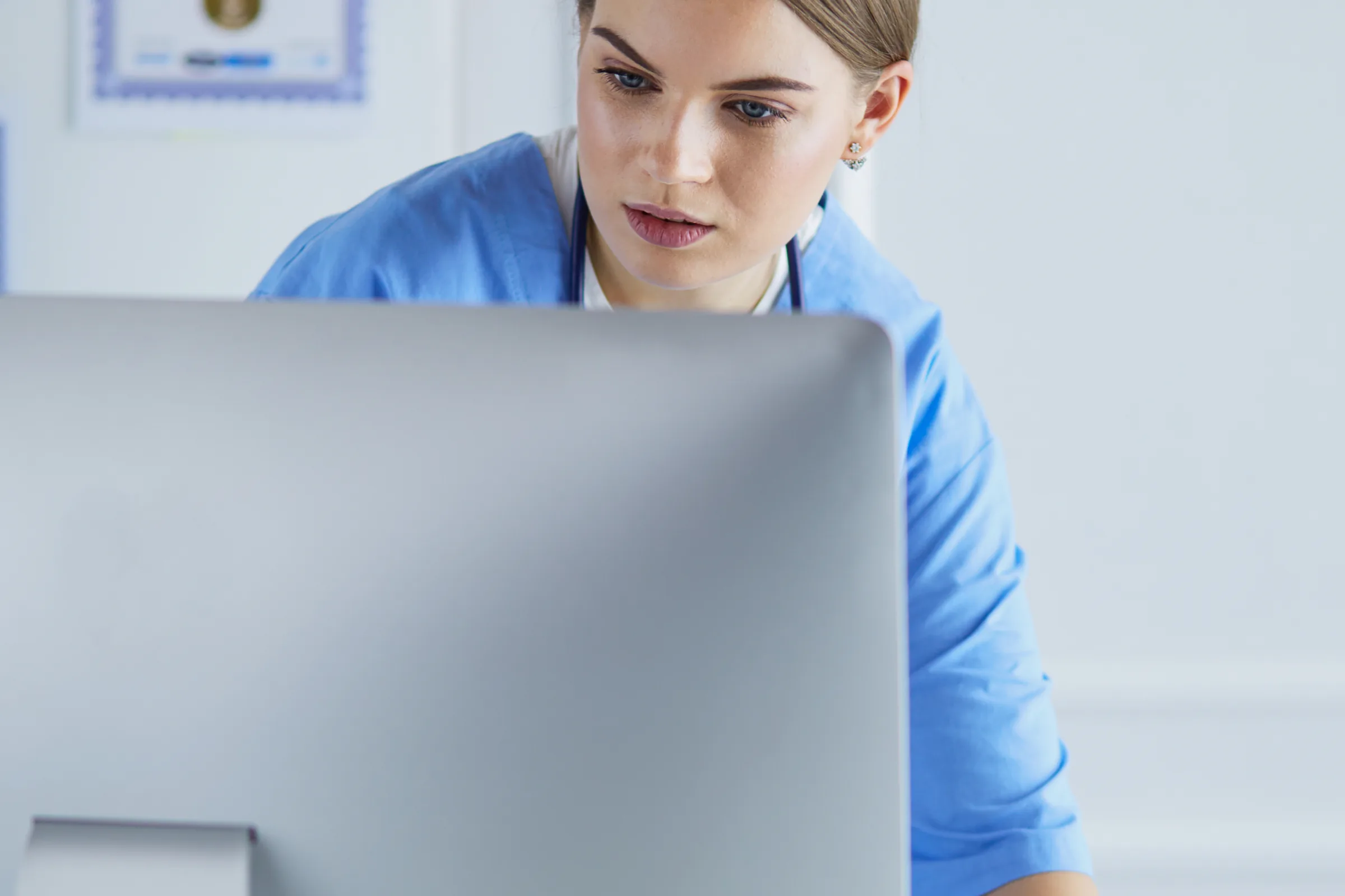Ärztin prüft Informationen an einem Computerarbeitsplatz