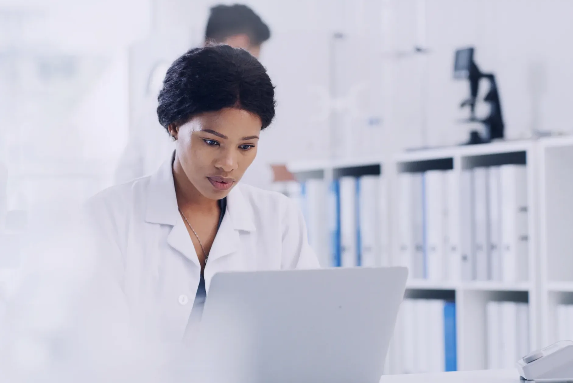 Forscherin prüft Studieninformationen an einem Laptop im Labor